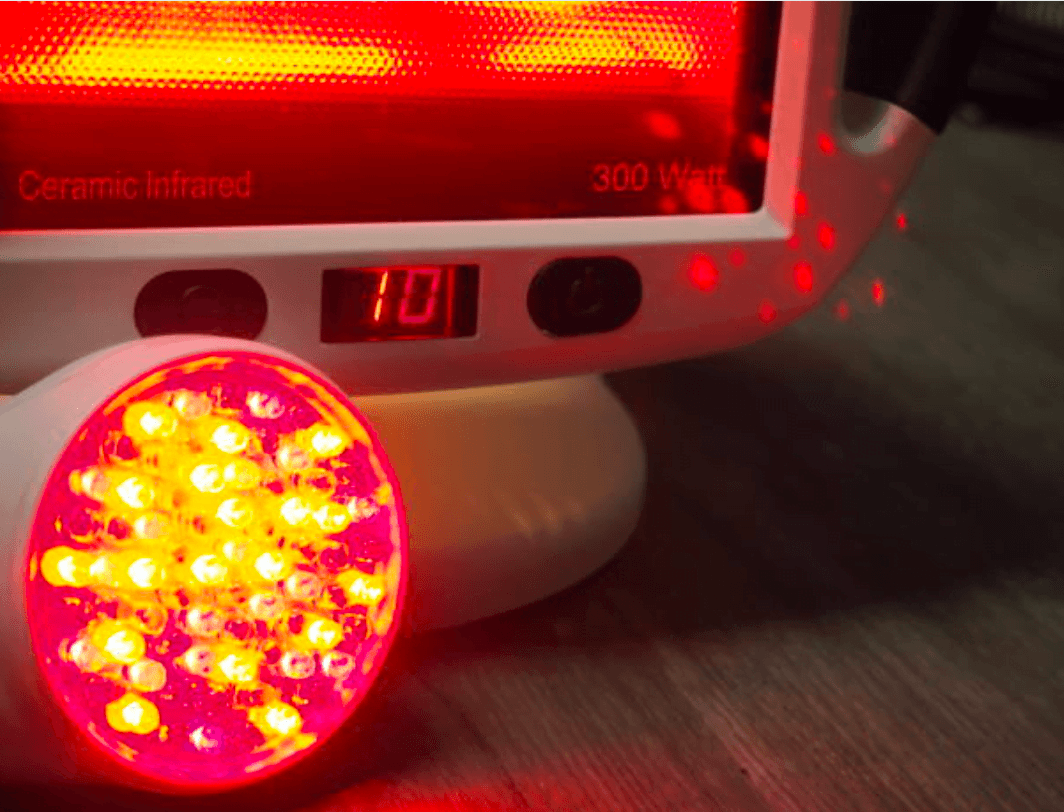 Close-up of an infrared lamp featuring glowing red LEDs, commonly used in red light therapy, with a digital display showing the number "101".