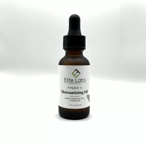 A brown glass bottle featuring a dropper and labeled with the product name "Elite Labs Vitamin C Moisturizing Oil.